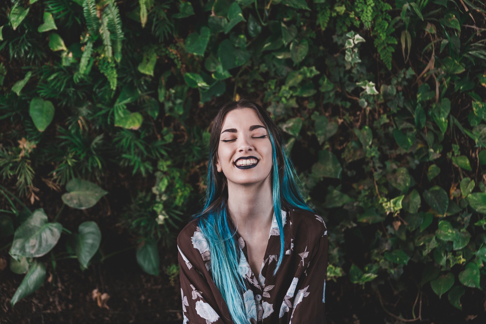 smiling-young-woman-standing-front-plant